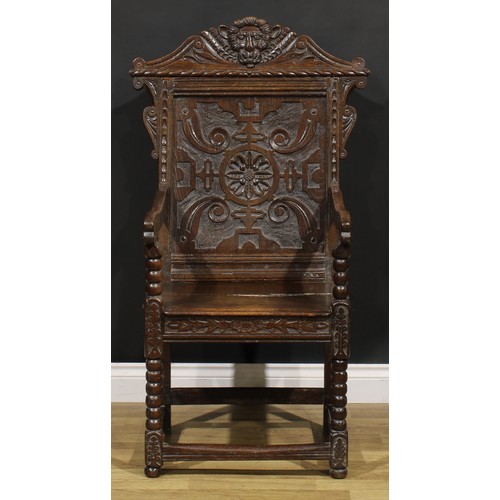 2077 - An 18th century oak wainscot armchair, shaped cresting carved with a lion mask, above a rectangular ... 