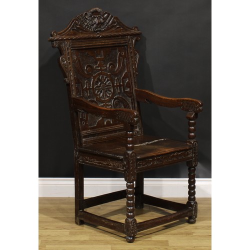 2077 - An 18th century oak wainscot armchair, shaped cresting carved with a lion mask, above a rectangular ... 