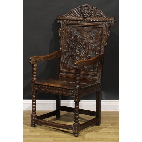 2077 - An 18th century oak wainscot armchair, shaped cresting carved with a lion mask, above a rectangular ... 