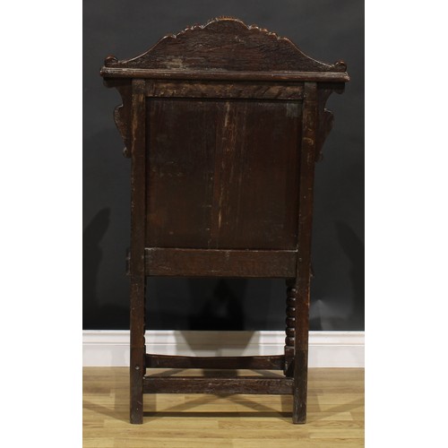 2077 - An 18th century oak wainscot armchair, shaped cresting carved with a lion mask, above a rectangular ... 