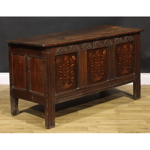 1583 - A Charles II oak blanket chest, the lunette carved frieze above three panels, inlaid in indigenous t... 