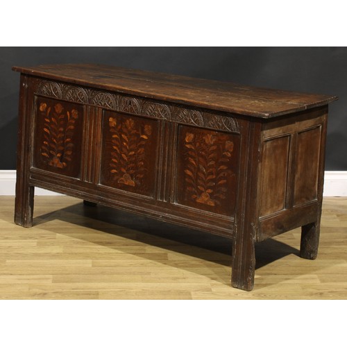 1583 - A Charles II oak blanket chest, the lunette carved frieze above three panels, inlaid in indigenous t... 