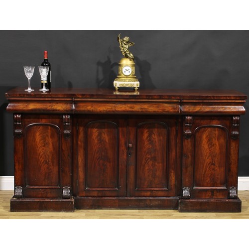 2113 - A Victorian flame mahogany sideboard, rectangular top above three concave moulded frieze drawers, th... 