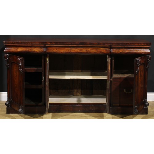 2113 - A Victorian flame mahogany sideboard, rectangular top above three concave moulded frieze drawers, th... 