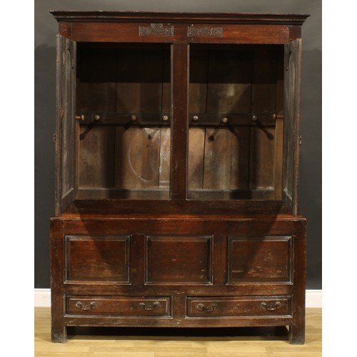 2115 - An 18th century oak bacon press or housekeeper’s cupboard, outswept cornice above a pair of arched r... 