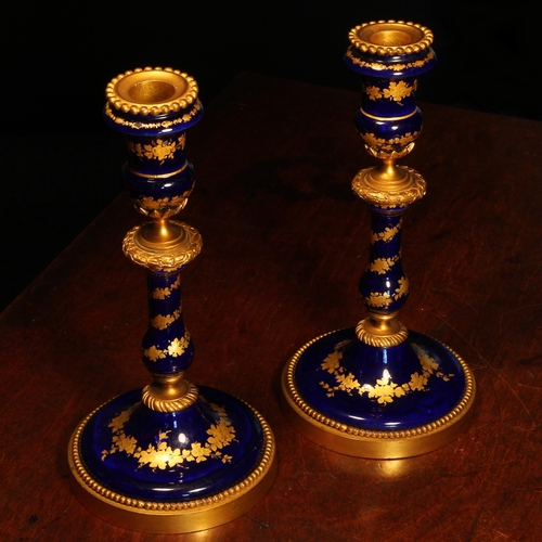 2167 - A pair of 19th century French gilt metal mounted enamel table candlesticks, decorated with bands of ... 