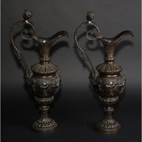 2136 - A pair of 19th century brown patinated bronze ewers, cast in the Grand Tour taste with bands of putt... 