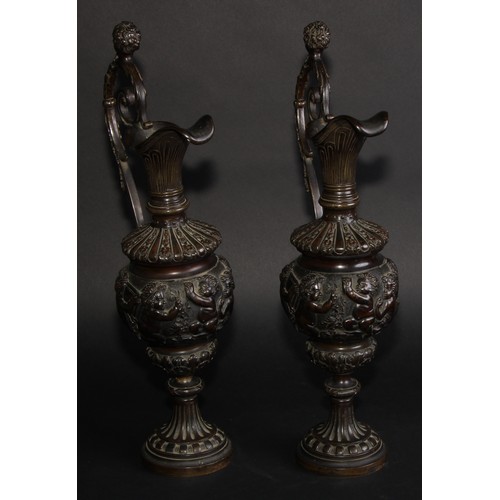 2136 - A pair of 19th century brown patinated bronze ewers, cast in the Grand Tour taste with bands of putt... 