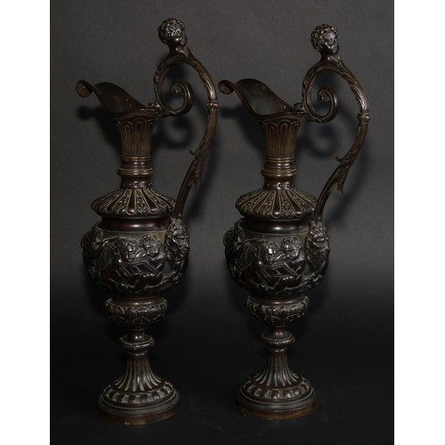 2136 - A pair of 19th century brown patinated bronze ewers, cast in the Grand Tour taste with bands of putt... 