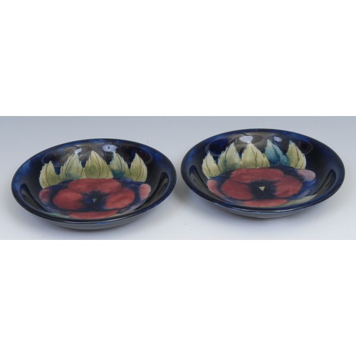 12 - A pair of Moorcroft Pansy pattern circular dishes, tube lined on a mottled blue ground, 18.5cm diame... 