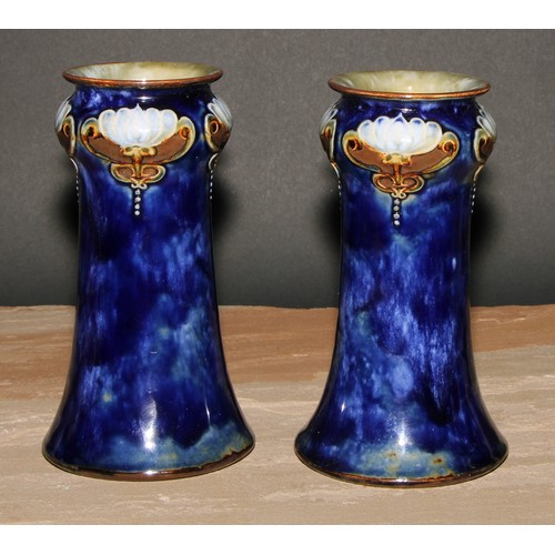 18 - A pair of Art Nouveau Royal Doulton stoneware vases, by Maud Bowden, moulded with stylised flowers a... 