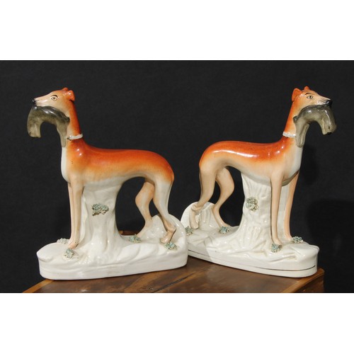 53 - A pair of 19th century Staffordshire hunting dogs, each retrieving hare, 28cm high