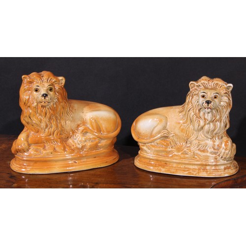54 - A pair of 19th century Staffordshire mantel lions, glass eyes, 24.5cm high