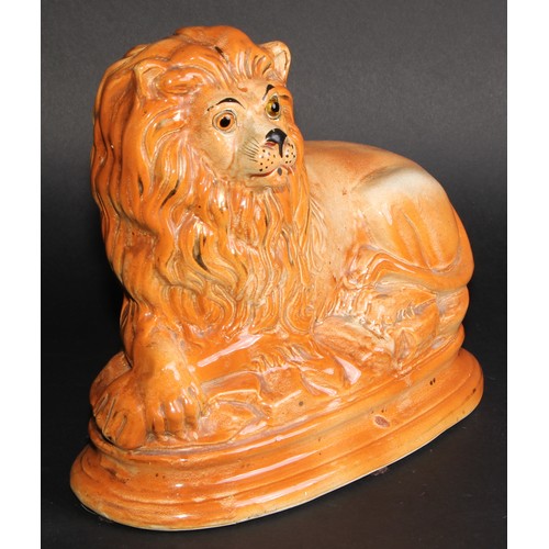 54 - A pair of 19th century Staffordshire mantel lions, glass eyes, 24.5cm high