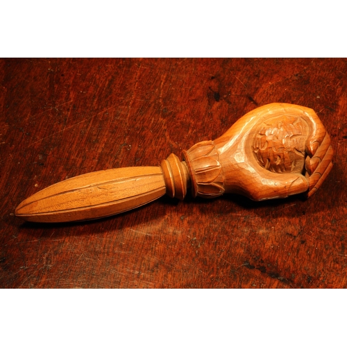 1101 - Nutcrackers - a Black Forest novelty screw-action nut cracker, carved as a fist grasping a walnut, l... 