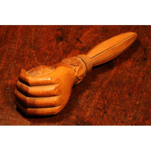 1101 - Nutcrackers - a Black Forest novelty screw-action nut cracker, carved as a fist grasping a walnut, l... 