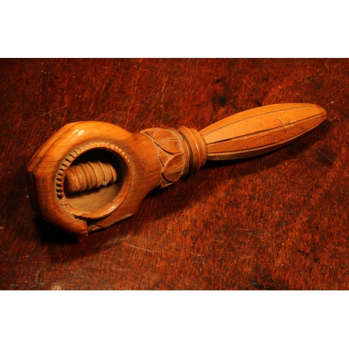 1101 - Nutcrackers - a Black Forest novelty screw-action nut cracker, carved as a fist grasping a walnut, l... 