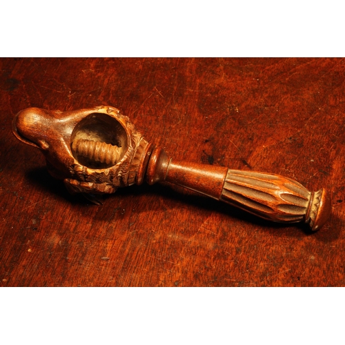 1105 - Nutcrackers - a Black Forest novelty screw-action nut cracker, carved as the head of a ram, lotus gr... 