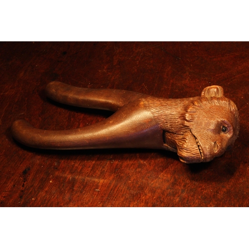 1076 - Nutcrackers - a Black Forest novelty lever action nut cracker, carved as the head of a monkey, glass... 