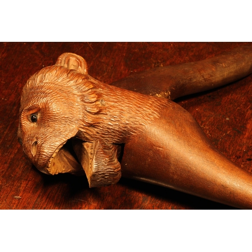 1076 - Nutcrackers - a Black Forest novelty lever action nut cracker, carved as the head of a monkey, glass... 