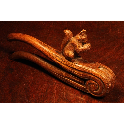 1093 - Nutcrackers - a Black Forest novelty lever-action nut cracker, carved as a squirrel on a branch, 22c... 