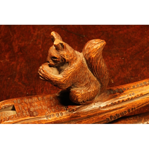 1093 - Nutcrackers - a Black Forest novelty lever-action nut cracker, carved as a squirrel on a branch, 22c... 