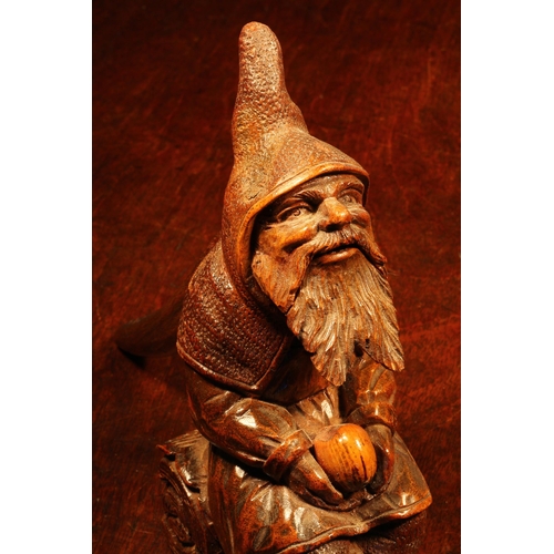 1110 - Nutcrackers - a Black Forest novelty table top lever-action nut cracker, carved as a bearded gnome s... 