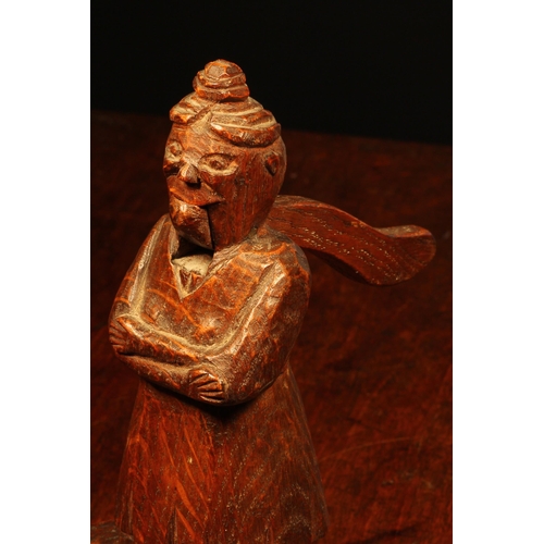 1158 - Nutcrackers - an early 20th century oak folk art table top nut cracker, naively carved as a figure s... 