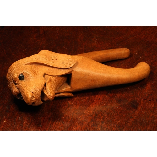 1097 - Nutcrackers - a Black Forest novelty lever-action nut cracker, carved as the head of a dog, glass ey... 