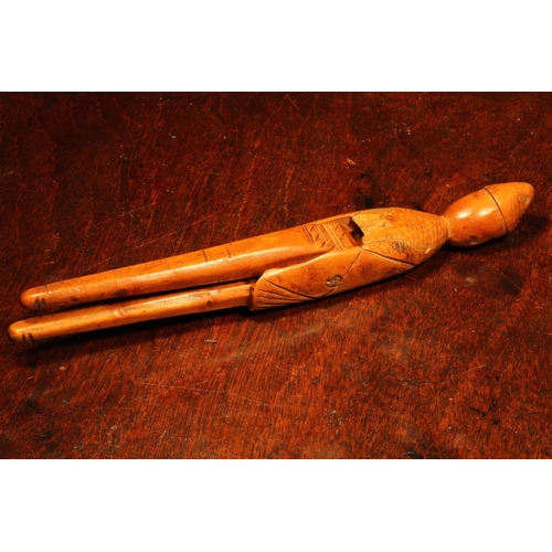 1144 - Nutcrackers - an early 18th century French boxwood figural lever-action nut cracker, of slender prop... 