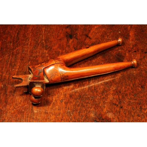 1139 - Nutcrackers - an 18th century yew wood crossover lever-action nut cracker, scrimshaw engraved with b... 