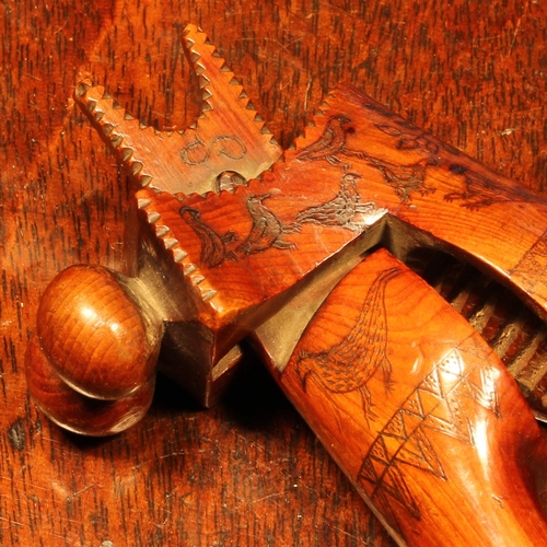 1139 - Nutcrackers - an 18th century yew wood crossover lever-action nut cracker, scrimshaw engraved with b... 