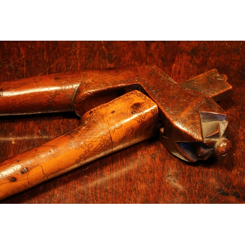 1140 - Nutcrackers - an 18th century yew wood crossover lever-action nut cracker, scrimshaw engraved with n... 