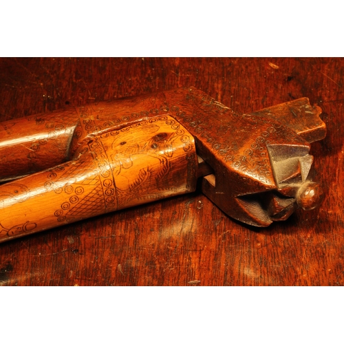 1140 - Nutcrackers - an 18th century yew wood crossover lever-action nut cracker, scrimshaw engraved with n... 