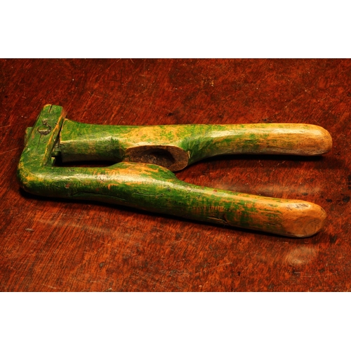 1121 - Nutcrackers - a late 18th century primitive crossover lever-action nut cracker, green painted surfac... 