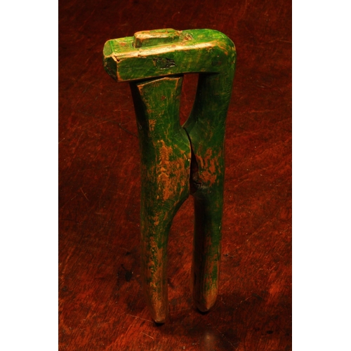 1121 - Nutcrackers - a late 18th century primitive crossover lever-action nut cracker, green painted surfac... 