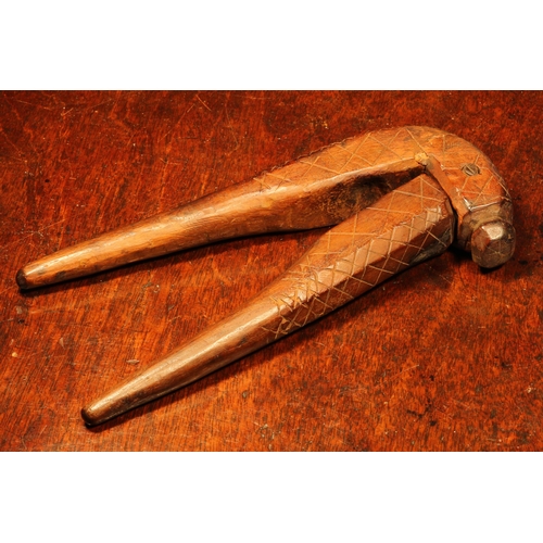 1133 - Nutcrackers - an 18th century fruitwood cross-over lever-action nut cracker, sgrafitto incised with ... 