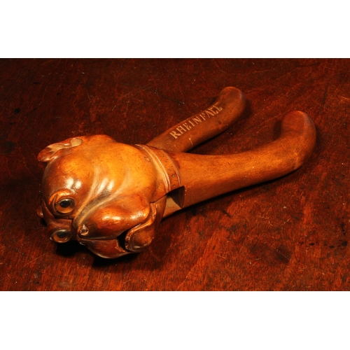 1075 - Nutcrackers - a Black Forest lever-action nut cracker, boldly carved as the head of a bulldog, glass... 