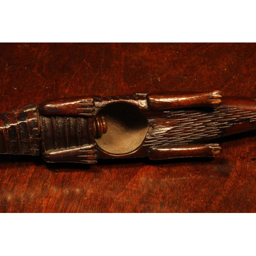 1155 - Nutcrackers - an early 19th century novelty screw-action nut cracker, carved as a crocodile, the tai... 