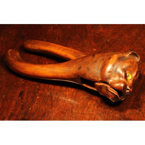 1095 - Nutcrackers - a Black Forest novelty lever-action nut cracker, carved as the head of a cat, glass ey... 