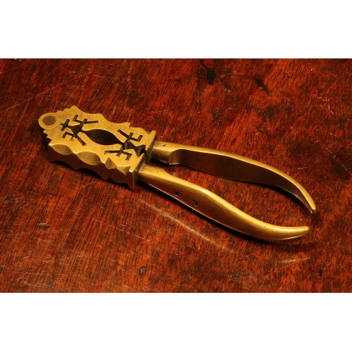 1159 - Nutcrackers - an unusual 18th century brass lever-action nut cracker, the jaws shaped and pierced in... 