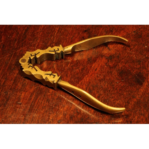 1159 - Nutcrackers - an unusual 18th century brass lever-action nut cracker, the jaws shaped and pierced in... 