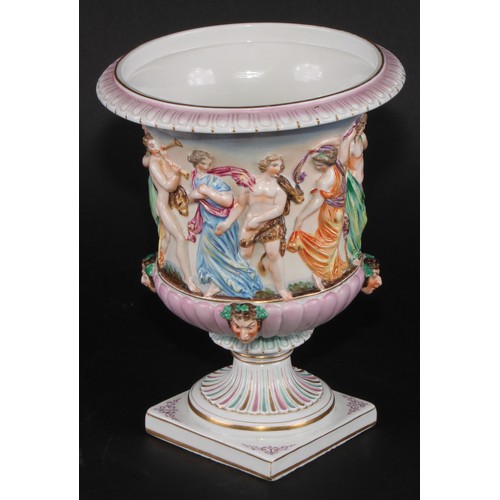 150 - A Naples porcelain campana shaped mantel urn, moulded in relief with classical figures dancing and p... 