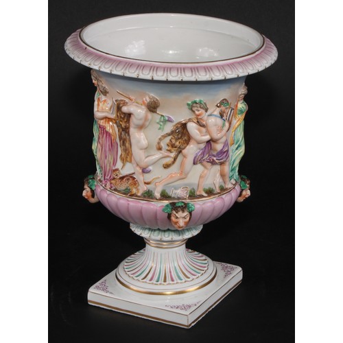 150 - A Naples porcelain campana shaped mantel urn, moulded in relief with classical figures dancing and p... 