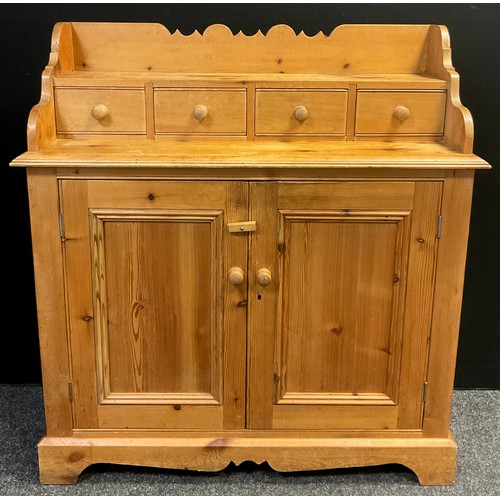 31 - A Scottish style pine small dresser, shaped galleried back, four short drawers to top, with a pair o... 