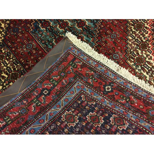 61 - A North West Persian Senneh rug / carpet, hand-knotted in rich tones of red, deep blue, turquoise, a... 