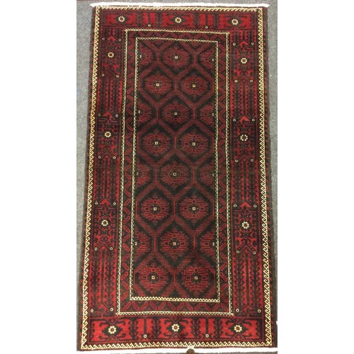 72 - A North East Persian Meshed Belouch rug / carpet, knotted with a geometric field, within a margins o... 