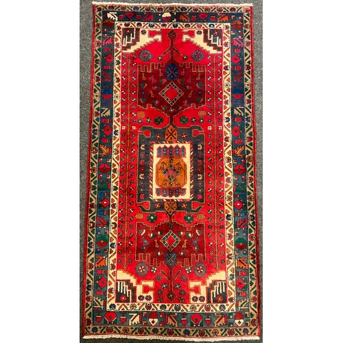 82 - A North West Persian Nahawand rug / carpet, in rich colours, red, green, blue, and cream, 230cm x 11... 