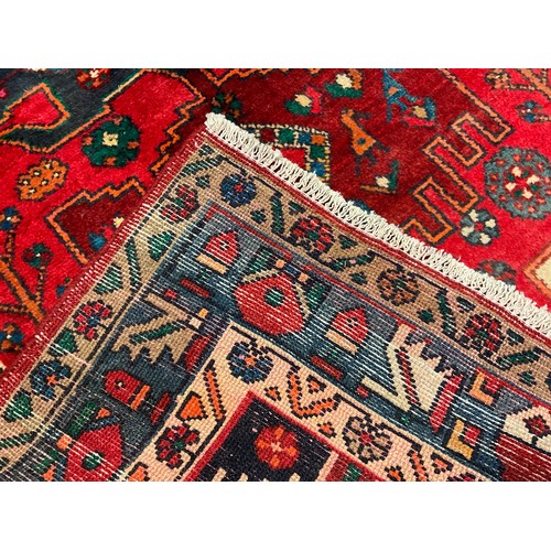 82 - A North West Persian Nahawand rug / carpet, in rich colours, red, green, blue, and cream, 230cm x 11... 