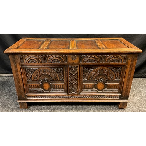 90 - An 18th century style carved oak coffee / blanket chest, four-panel hinged top, carved front, block ... 